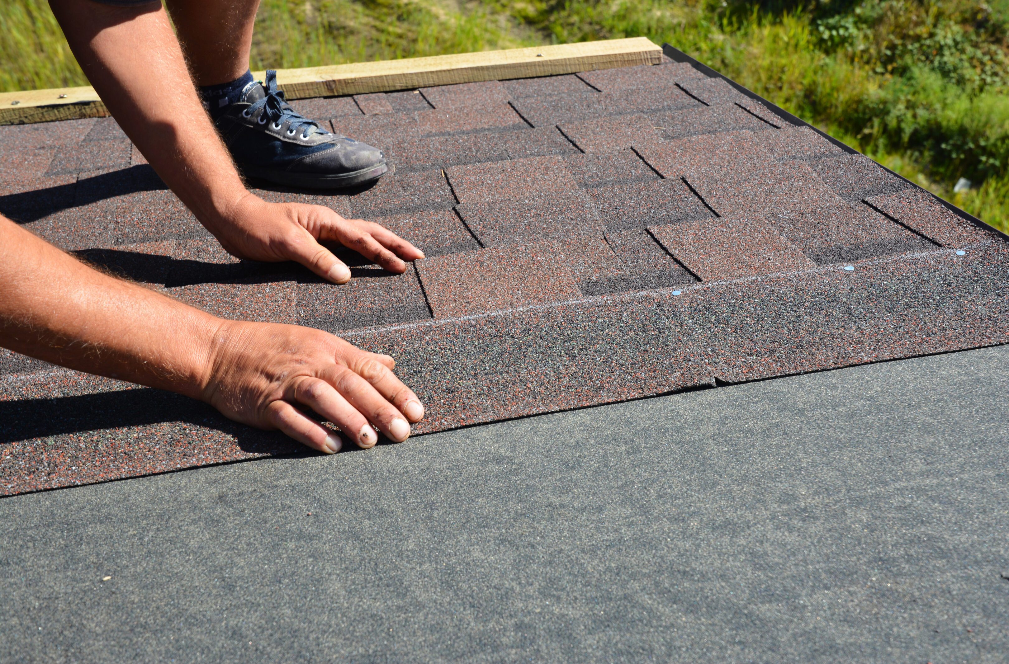 Installing asphalt shingles on a roof.